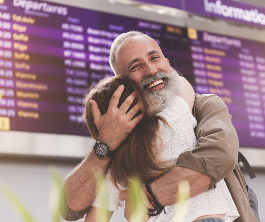 man hugging woman at airport