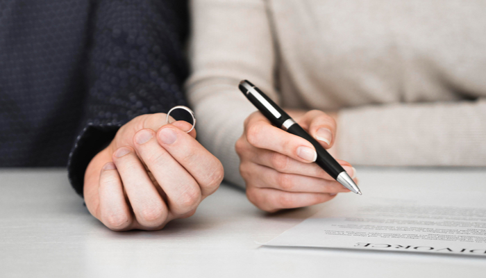 Husband and wife signing divorce settlement or separation agreement