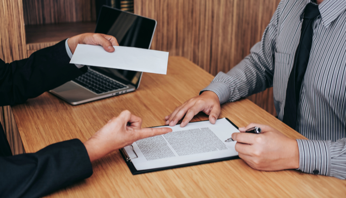 Hand of employer filing final paycheck after employee to write a document letter of resignation, end of contract concept